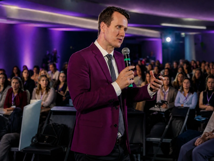 Dr. Leonardo palestrando ao microfone na imersão presencial do HORMOFEM