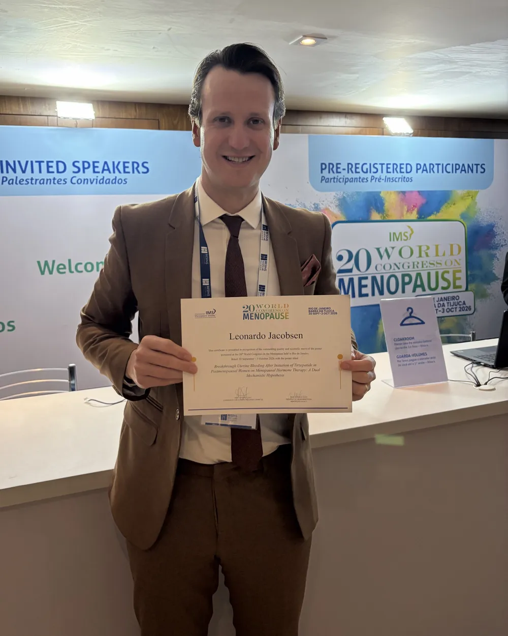 Dr. Leonardo Jacobsen segurando o certificado da menção honrosa da International Menopause Society