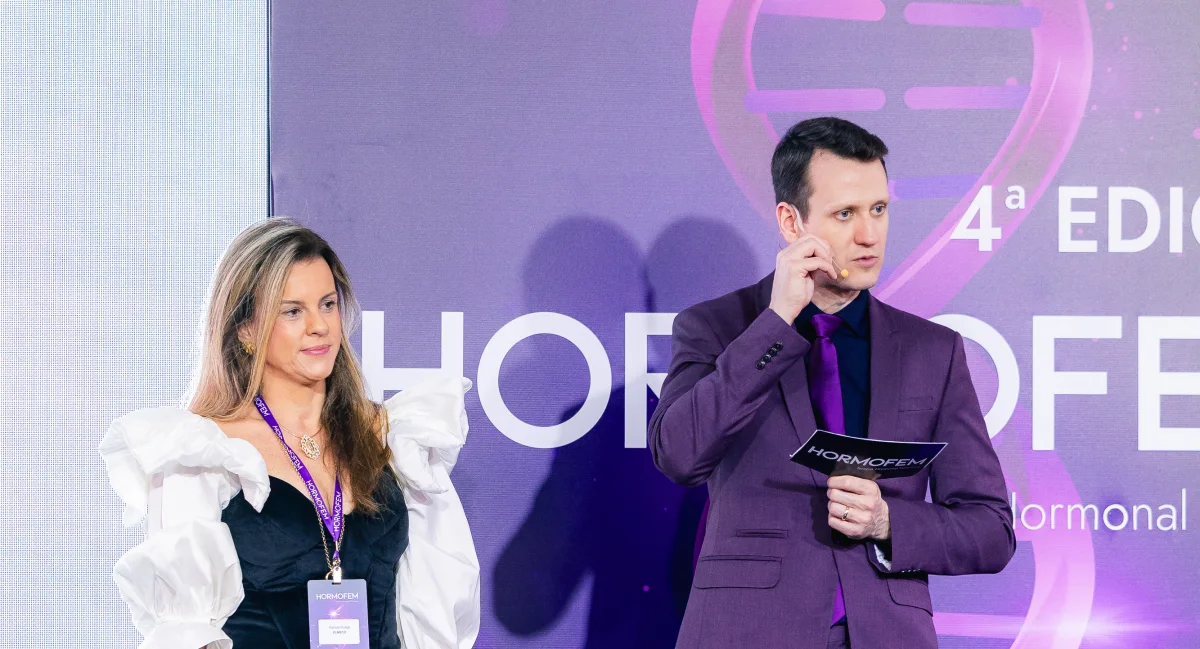 Representante do patrocinador falando no palco, diante da turma